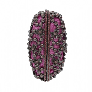 Close-up of pink glitter evening bag with grey hollow metal floral overlay and rhinestones