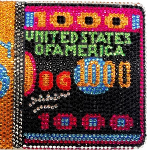 Macro detail of luxury dinner clutch featuring multicolor rhinestones and dollar bill motifs
