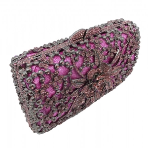 Detail of purple jewel evening clutch featuring hollow flower metal and inlaid crystals