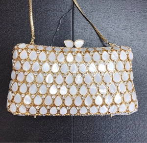 Detailed close-up of shell-shaped dual clasps on luxury gold crystal evening clutch bag