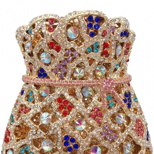 Macro shot of luxury evening clutch bag featuring colorful rhinestones and gold hollow metalwork