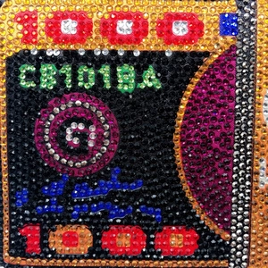 Macro detail of high-density colorful rhinestones forming a dollar pattern on evening bag