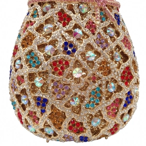 Close-up of golden hollow metal evening clutch with colorful sparkling rhinestones