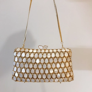Detailed view of teardrop shell evening bag with butterfly clasp and gold chain strap