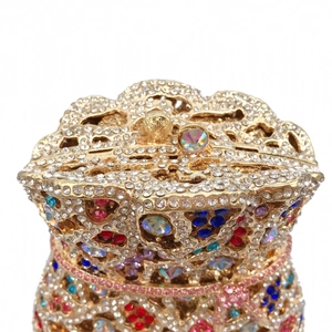 Detailed view of luxury gold evening clutch bag with sparkling rhinestones and crown clasp