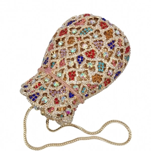 Macro detail of luxury gold drawstring evening bag with colorful crystals and chain