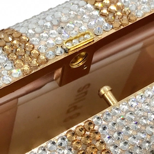 Dettaglio macro della borsa da sera Dollar con strass brillanti e chiusura in oro lucido