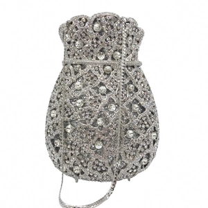Detailed close-up of a silver bucket-shaped evening bag with intricate crystal pavé and hollow pattern