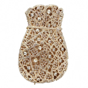 Detailed macro view of champagne gold evening bag with intricate hollow metalwork and crystals