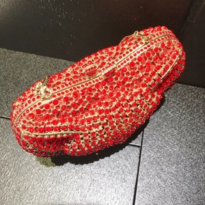 Macro view of red rhinestones and gold metal frame on an elegant animal evening bag