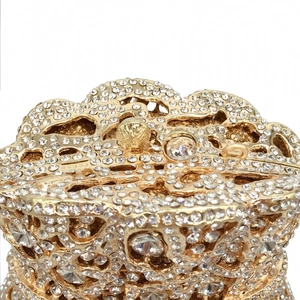 Close-up of golden hollow evening bag with sparkling rhinestones and crystal clasp