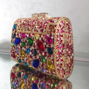Detailed close-up of a luxury evening clutch with colorful rhinestones and gold hollow frame