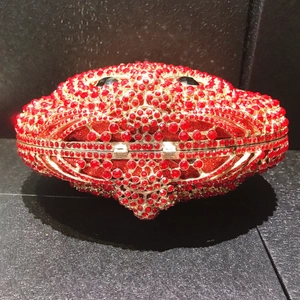 Macro view of crab-shaped evening clutch bag with red rhinestones and metal clasp