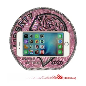 Macro detail of round pink rhinestone clutch showing interior capacity for a smartphone
