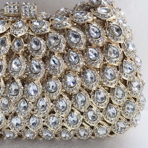 Close-up of luxury evening clutch with pear-cut crystals and gold metal hardware