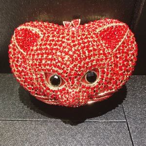 Macro shot of owl evening bag featuring red rhinestones and black gem eyes detail