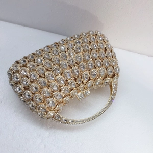 Detailed view of luxury evening clutch with teardrop crystals and gold metal ring handle