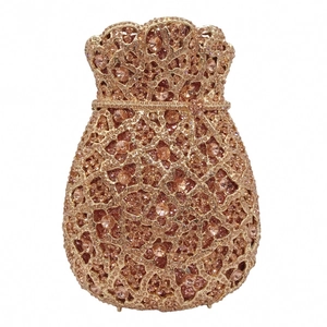 Macro shot of champagne gold evening bag featuring hollow floral pattern and crystal inlay