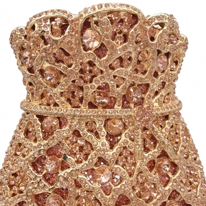 Close-up of sparkling crystals and intricate metal hollow design on champagne evening bag