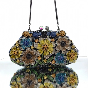 Macro view of crystal encrusted floral pattern on a luxury evening clutch with metal chain