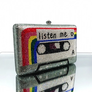 Macro view of crystal encrusted cassette tape clutch with rainbow stripe and listen me text