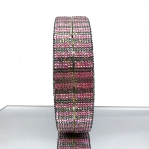 Macro side view of crystal evening clutch bag with pink and silver rhinestone stripes