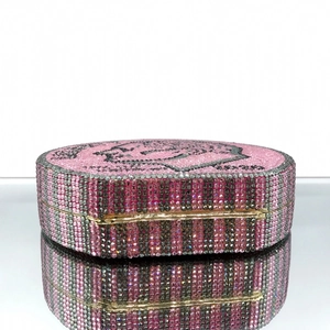 Macro shot of hand-set pink and grey rhinestones on a luxury round dollar-style clutch bag
