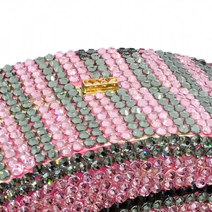 Detailed macro of pink and grey striped rhinestone clutch with gold metal clasp
