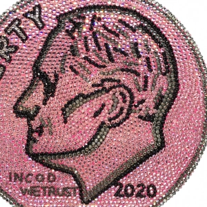 Macro shot of pink rhinestone encrusted round coin bag with Liberty profile detail