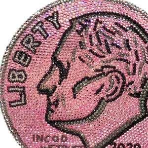Macro shot of pink and silver crystal rhinestones on the circular coin-shaped evening bag