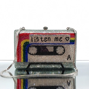 Macro view of crystal tape clutch with colorful rainbow stripes and listen me engraving