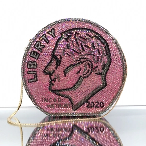 Close-up of pink round rhinestone evening bag with dollar coin liberty pattern