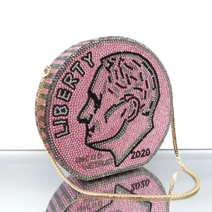 Close-up of pink crystal encrusted coin-shaped evening clutch with Liberty motif