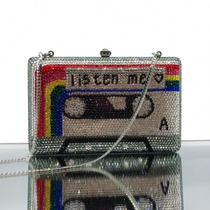 Macro shot of cassette-shaped clutch with silver crystals and rainbow stripes on mirror