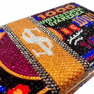 Gros plan détaillé des cristaux multicolores sur la pochette de luxe en forme de dollars