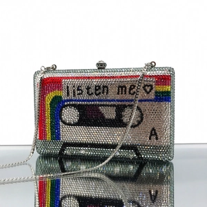 Macro detail of retro cassette evening clutch with rainbow crystals and listen me engraving