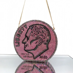 Close-up of pink and black rhinestones on a round coin-shaped luxury evening clutch bag