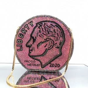 Macro shot of pink rhinestone encrusted dime coin evening bag with gold chain strap