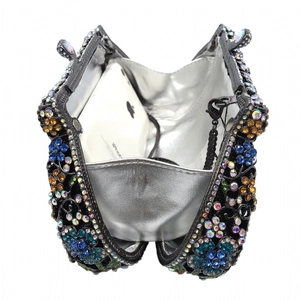 Luxurious floral evening clutch showing interior capacity with a smartphone inside