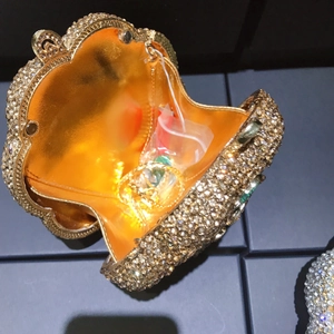 Macro view of shell-shaped evening clutch showing crystal studs and gold metal lining