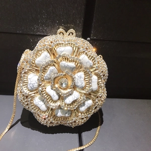 Detailed view of floral evening clutch with marble petals and sparkling rhinestones