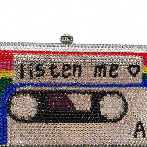 Macro detail of retro cassette tape clutch bag featuring multi-color sparkling rhinestones