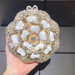 Close-up of floral evening clutch with crystals and white marble stone textures