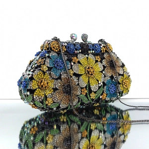 Macro detail of luxury evening clutch with colorful floral crystals and silver chain
