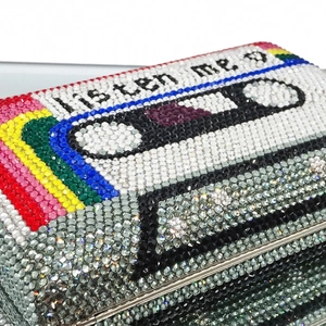 Detailed close-up of retro cassette evening clutch encrusted with colorful crystals