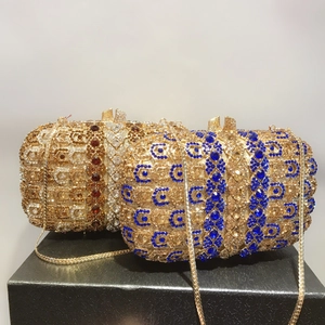 Détail de pochettes de soirée de luxe avec cristaux bleus et ambre et chaîne dorée