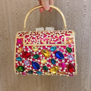 Detail of rose red evening bag with multi-colored teardrop gems and golden floral metalwork