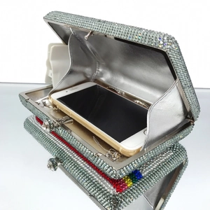 Detail showing the open crystal clutch interior and colorful rhinestone stripes