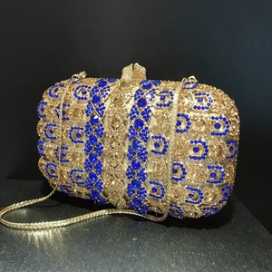 Vue détaillée de la pochette de soirée en cristaux bleus et dorés avec bandoulière chaîne