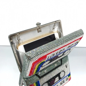 Detailed interior of retro cassette clutch showing phone capacity and rainbow rhinestones